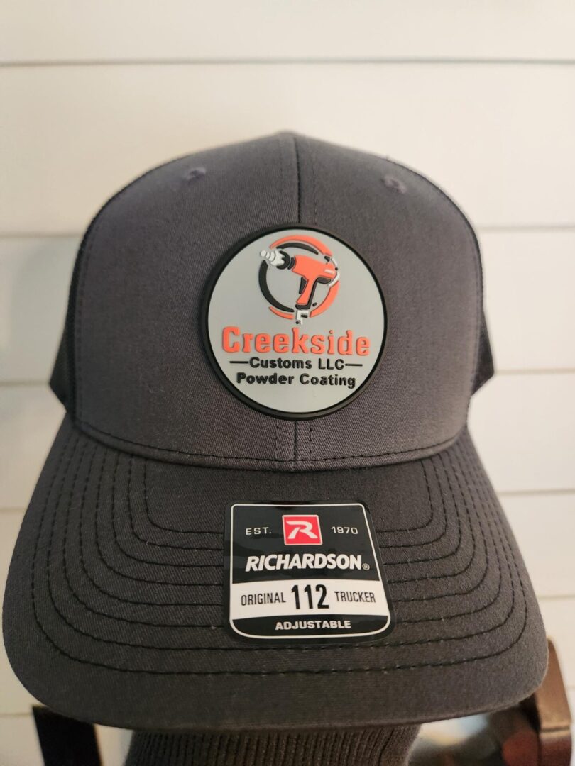 A gray hat with an orange and black patch on it.