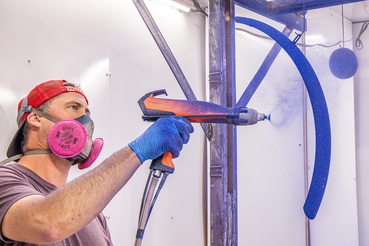 A man holding two handles with a paint gun.