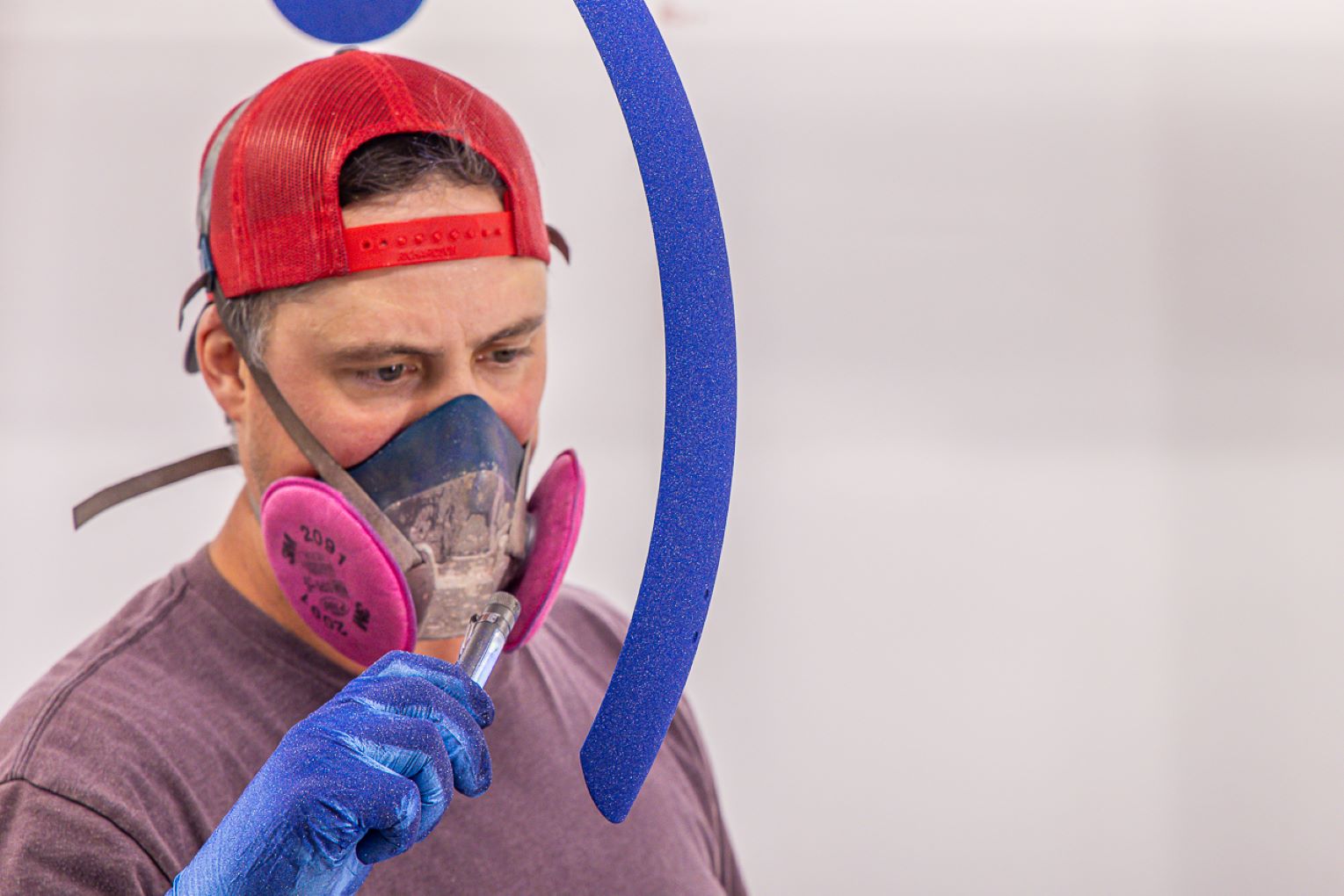 A man wearing blue gloves and a red hat.